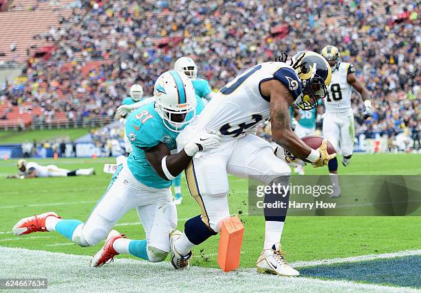 Todd Gurley of the Los Angeles Rams scores a touchdown in front of Michael Thomas of the Miami Dolphins in the first quarter of the game at Los...