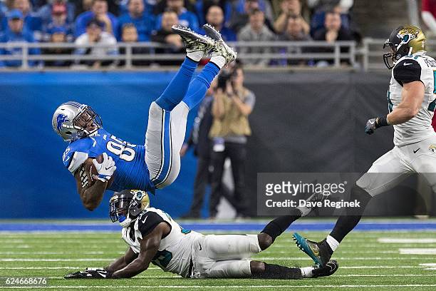 Eric Ebron of the Detroit Lions is tackled by Tashaun Gipson of the Jacksonville Jaguars during the second half of an NFL game at Ford Field on...