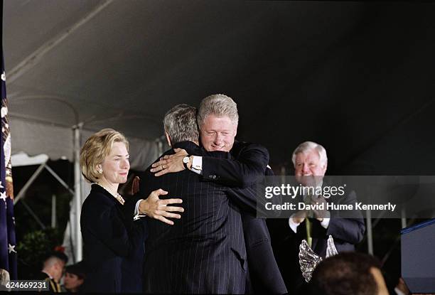 President Bill Clinton hugs attorney Brian O'Dwyer after receiving the Paul O'Dwyer award at the White House during an event promoting peace in...