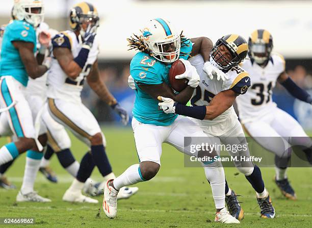 McDonald of the Los Angeles Rams tries to stop Jay Ajayi of the Miami Dolphins during the first quarter of the game at Los Angeles Coliseum on...