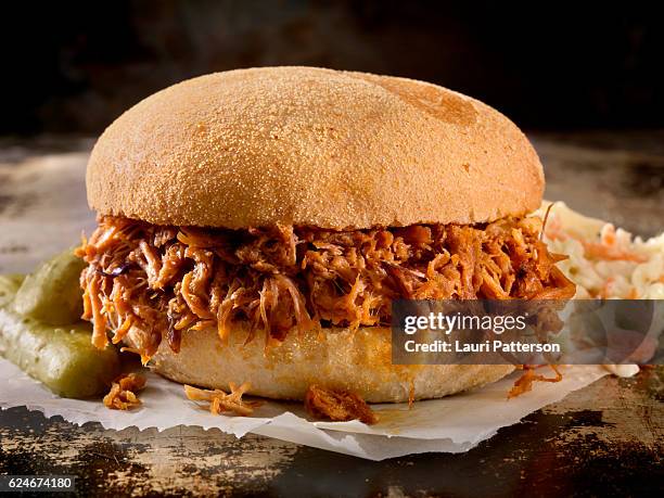 sandwich di maiale tirato in una salsa barbecue salata con coleslaw - bbq sandwich foto e immagini stock
