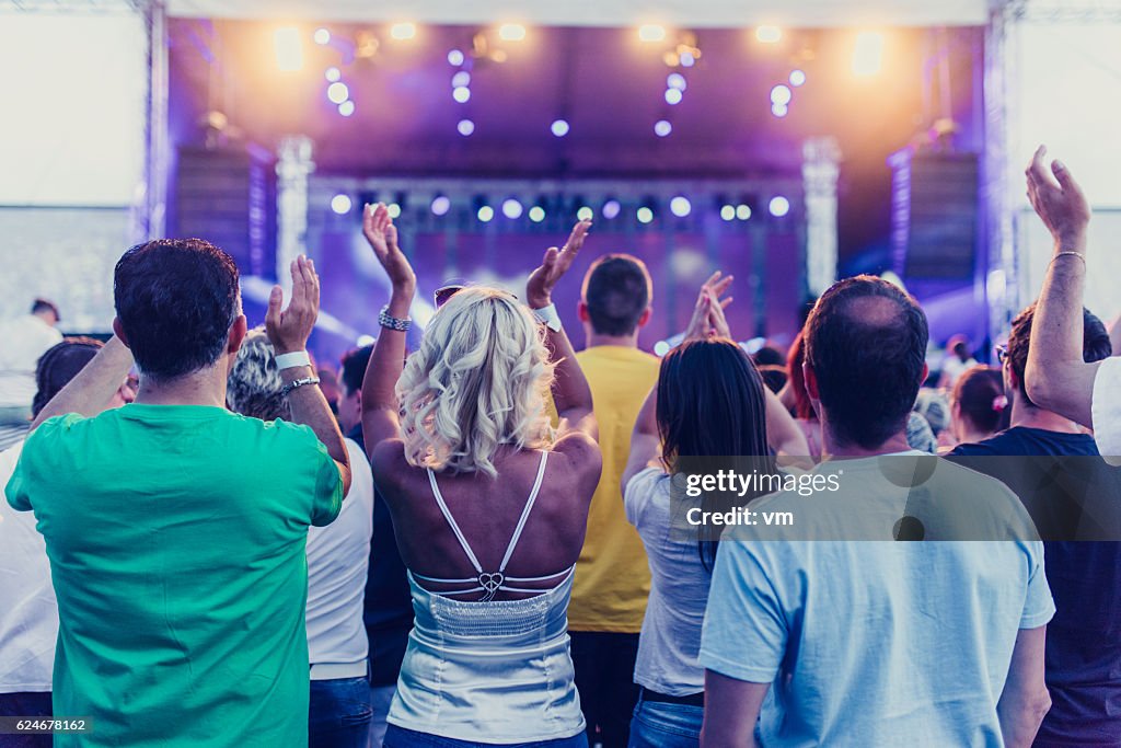 Menschen bei einem Konzert hören und klatschen
