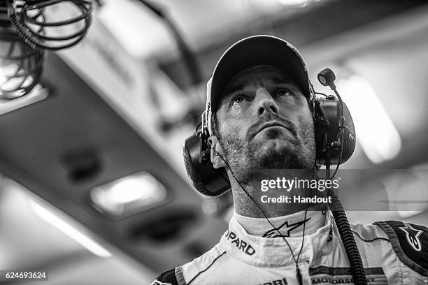 In this handout image provided by Red Bull, #1 Porsche LMP1 car driver Mark Webber of Australia watches the timing screens in the garage waiting for...