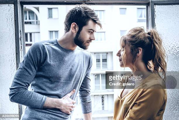 jeune homme beau et belle femme se regardant à la fenêtre - métier d'art femme chic photos et images de collection