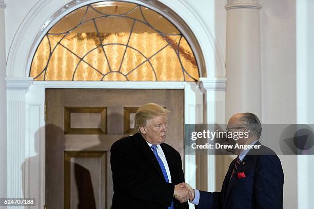 President-elect Donald Trump and former New York City mayor Rudy Giuliani shake hands following their meeting at Trump International Golf Club,...