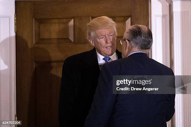 President-elect Donald Trump and former New York City mayor Rudy Giuliani talk to each other as they exit the clubhouse following their meeting at...