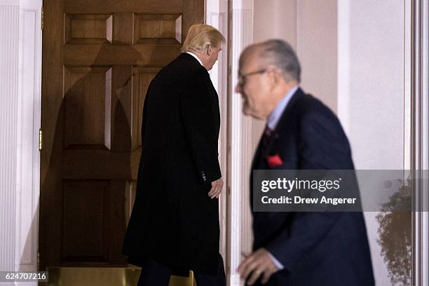 President-elect Donald Trump heads back inside as former New York City mayor Rudy Giuliani walks to his car following their meeting at Trump...