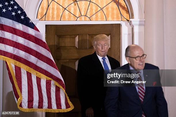 President-elect Donald Trump and former New York City mayor Rudy Giuliani exit the clubhouse following their meeting at Trump International Golf...