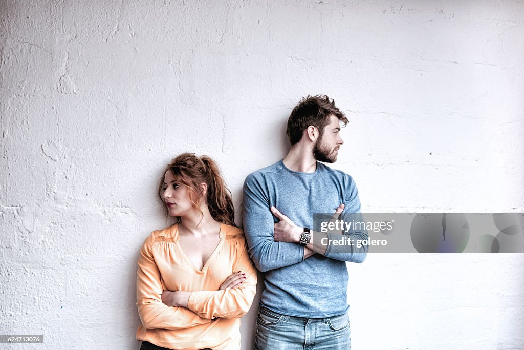 Ernsthafte junge französische Paar blickin in entgegengesetzte Richtungen