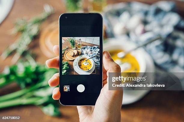 mujer tomando foto de sopa de calabaza con smartphone - mensaje de móvil fotografías e imágenes de stock