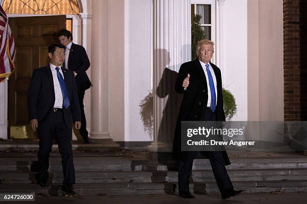 Trailed by U.S. Secret Service agents, President-elect Donald Trump leaves the clubhouse following a full day of meetings at Trump International Golf...