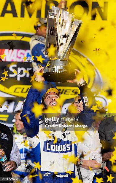 Jimmie Johnson, driver of the Lowe's Chevrolet, celebrates with the NASCAR Sprint Cup Series Championship trophy in Victory Lane after winning the...