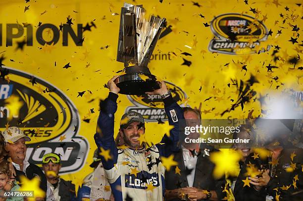 Jimmie Johnson, driver of the Lowe's Chevrolet, celebrates with the NASCAR Sprint Cup Series Championship trophy in Victory Lane after winning the...