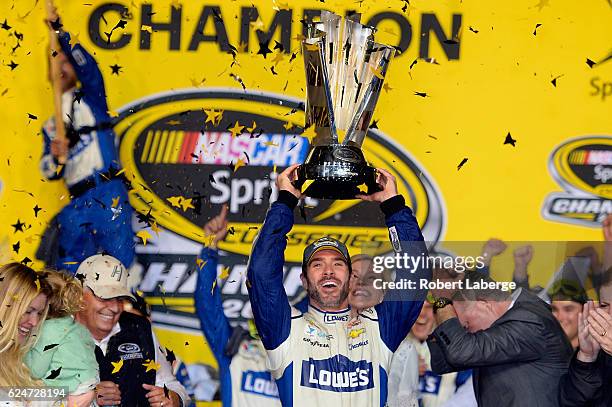 Jimmie Johnson, driver of the Lowe's Chevrolet, celebrates with the NASCAR Sprint Cup Series Championship trophy in Victory Lane after winning the...