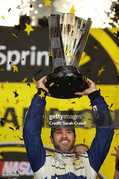 Jimmie Johnson, driver of the Lowe's Chevrolet, celebrates with the NASCAR Sprint Cup Series Championship trophy in Victory Lane after winning the...