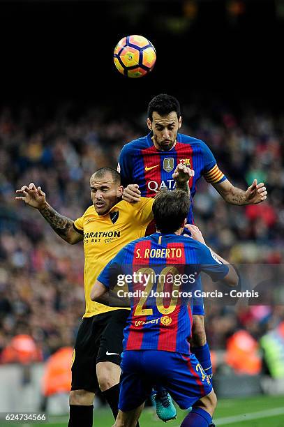 Sergio Busquets and Sergi Roberto of FC Barcelona compete for the ball with Sandro Ramírez of Malaga CF, during the Spanish League match between FC...