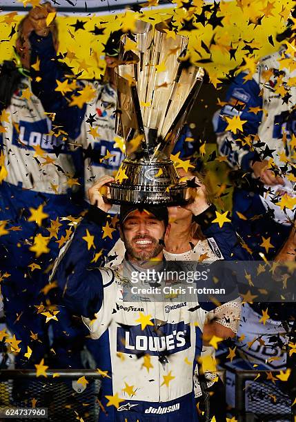 Jimmie Johnson, driver of the Lowe's Chevrolet, celebrates with the NASCAR Sprint Cup Series Championship trophy in Victory Lane after winning the...