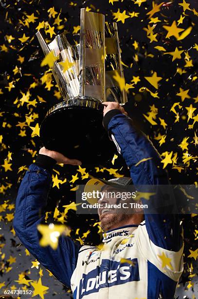 Jimmie Johnson, driver of the Lowe's Chevrolet, celebrates with the NASCAR Sprint Cup Series Championship trophy in Victory Lane after winning the...