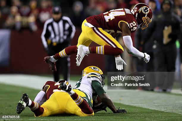 Wide receiver Ty Montgomery of the Green Bay Packers is tackled by safety Donte Whitner and cornerback Josh Norman of the Washington Redskins in the...