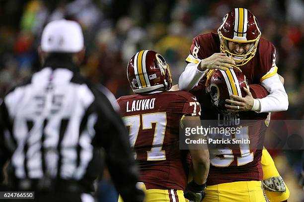 Quarterback Kirk Cousins of the Washington Redskins celebrates with teammates center Spencer Long and guard Shawn Lauvao after throwing a fourth...