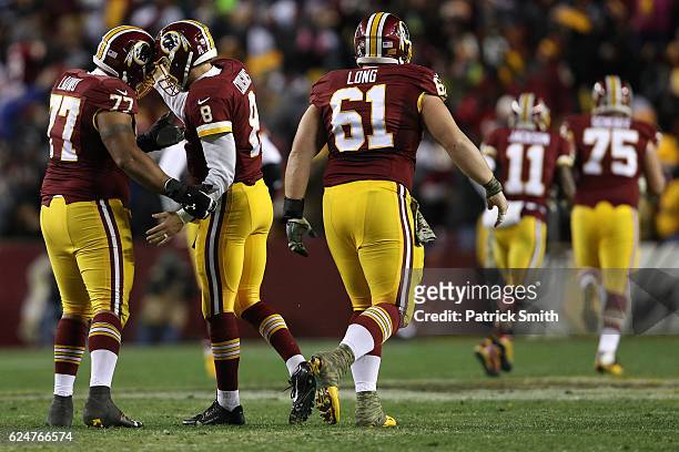 Quarterback Kirk Cousins of the Washington Redskins celebrates with teammates center Spencer Long and guard Shawn Lauvao after throwing a fourth...