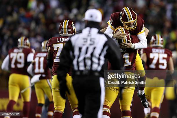 Quarterback Kirk Cousins of the Washington Redskins celebrates with teammates center Spencer Long and guard Shawn Lauvao after throwing a fourth...