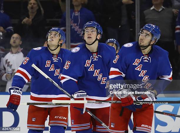 Brady Skjei, Jimmy Vesey, and Mika Zibanejad of the New York Rangers rwatch a replay on teh scoreboard during the second period against the Florida...