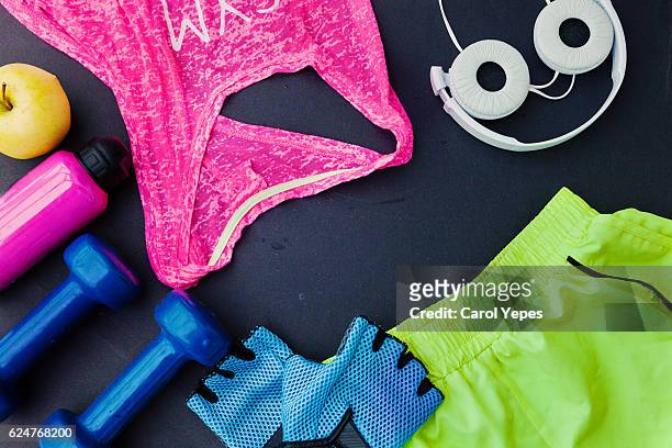 flat lay shot of woman sport equipment, shoes, water, earphone and phone on wooden background - clothing shot flat stock-fotos und bilder