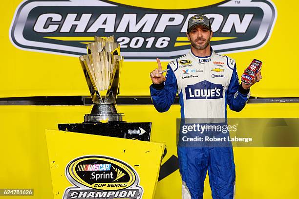 Jimmie Johnson, driver of the Lowe's Chevrolet, poses with the NASCAR Sprint Cup Series Championship trophy in Victory Lane after winning the NASCAR...