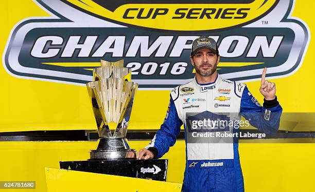 Jimmie Johnson, driver of the Lowe's Chevrolet, poses with the NASCAR Sprint Cup Series Championship trophy in Victory Lane after winning the NASCAR...