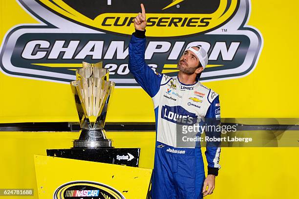Jimmie Johnson, driver of the Lowe's Chevrolet, poses with the NASCAR Sprint Cup Series Championship trophy in Victory Lane after winning the NASCAR...