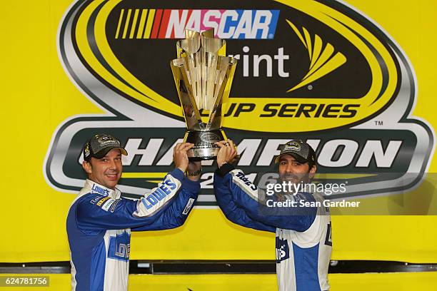 Jimmie Johnson , driver of the Lowe's Chevrolet, poses with crew chief Chad Knaus and the NASCAR Sprint Cup Series Championship trophy in Victory...