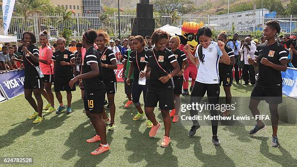 England and Arsenal footballer Alex Scott learns the 'Two step' dance with the Papua New Guinea team at the FanZone during the FIFA U-20 Women's...