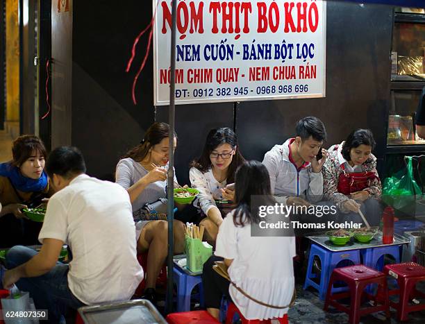 Hanoi, Vietnam Young people eat at a snack bar on a street in Hanoi on October 30, 2016 in Hanoi, Vietnam.