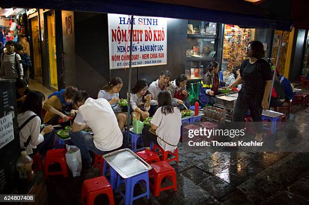 Hanoi, Vietnam Young people eat at a snack bar on a street in Hanoi on October 30, 2016 in Hanoi, Vietnam.