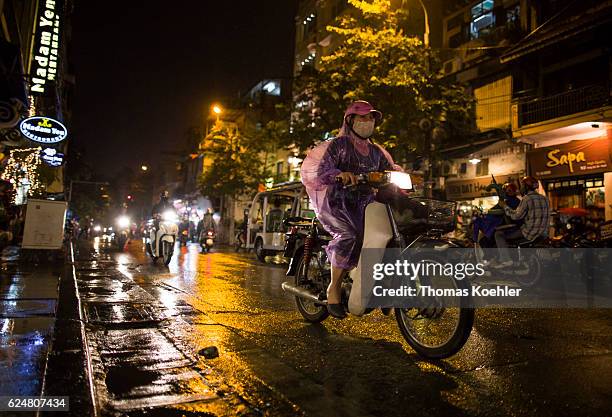 Hanoi, Vietnam A woman with a respiratory mask is driving on a motorbike in the evening traffic of Hanoi on October 30, 2016 in Hanoi, Vietnam.