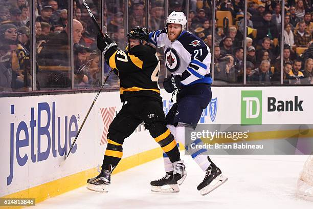 Quinton Howden of Winnipeg Jets checks against Torey Krug of the Boston Bruins at the TD Garden on November 19, 2016 in Boston, Massachusetts.