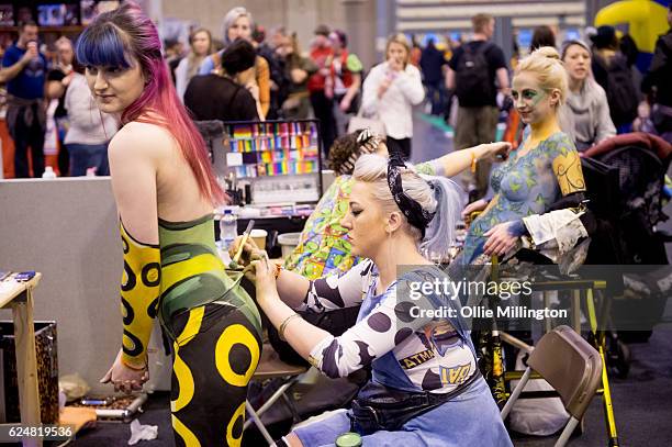 Body paint artists working on models throughout day 2 of the November Birmingham MCM Comic Con at the National Exhibition Centre in Birmingham, UK on...