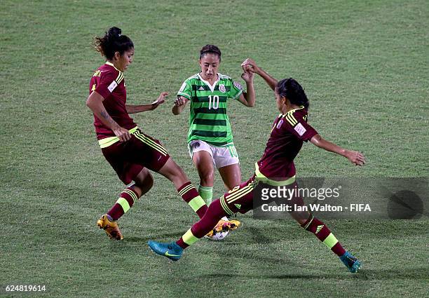 Eva Gonzalez of Mexico is tackled by Gabriela Garcia and Idalys Perez of Venezuela during the FIFA U-20 Women's World Cup, Group D match between...