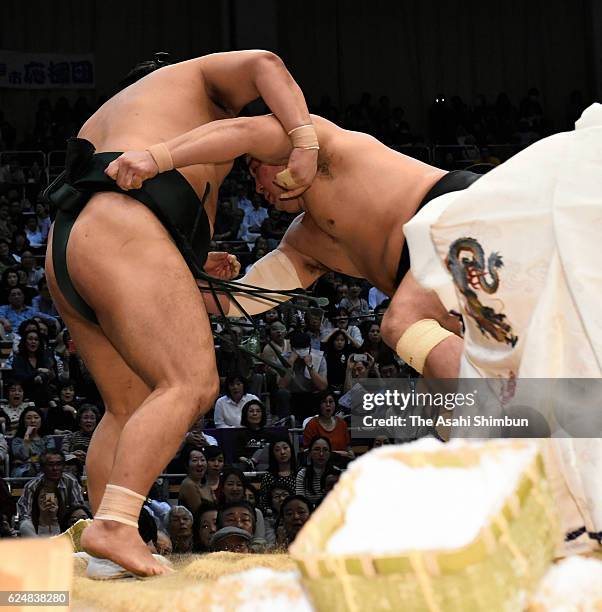 Mongolian yokozuna Harumafuji throws sekiwake Okinoumi to win during day nine of the Grand Sumo Kyushu Tournament at Fukuoka Convention Center on...