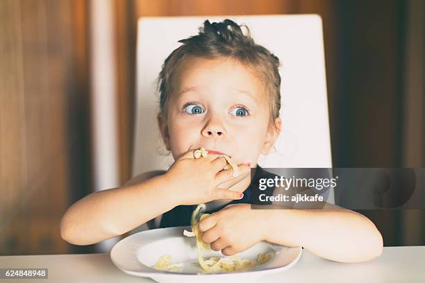 kleines mädchen essen-pasta - etiquette stock-fotos und bilder