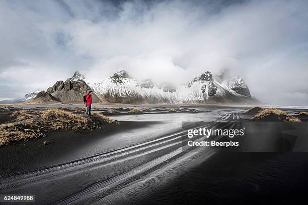 vestrahorn mountain with traveler in the east of iceland. - arctic explorer stock pictures, royalty-free photos & images