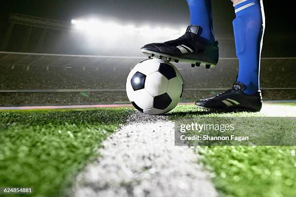 athlete with foot on soccer ball in stadium - studded stock pictures, royalty-free photos & images