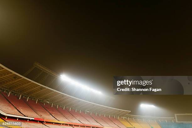 view of empty stadium with lights at night - stadion flutlicht stock-fotos und bilder
