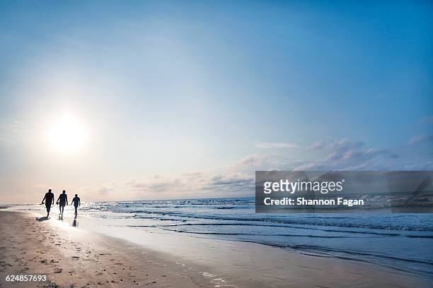 people walking on beach at sunrise - hilton head stock pictures, royalty-free photos & images