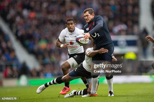 Alex Goode of England offloads under press from a diving Metuisela Tabebula of Fiji during Old Mutual Wealth Series between England and Fiji played...