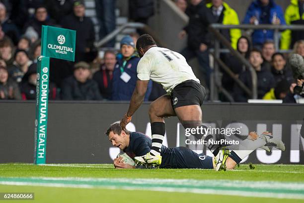 Alex Goode of England scores a try beyond the diving tackle of Peni Ravai of Fiji during Old Mutual Wealth Series between England and Fiji played at...