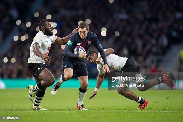 Alex Goode of England runs at Asaeli Tikoirotuma and Metuisela Tabebula of Fiji during Old Mutual Wealth Series between England and Fiji played at...