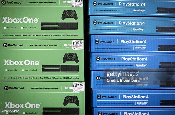 Pre-owned Microsoft Corp. Xbox One, left, and Sony Corp. PlayStation 4 gaming consoles are displayed for sale at a GameStop Corp. Store in Chicago,...