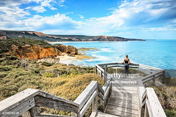 a woman look at ocean at bells beach near torquay, victoria, australia, south pacific - torquay stock pictures, royalty-free photos & images